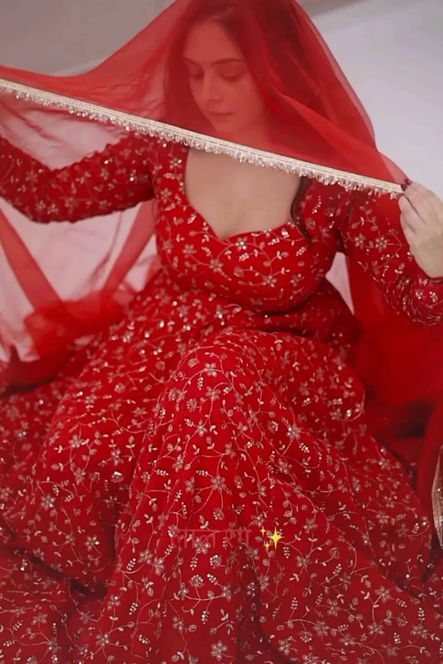 Red traditional outfit with floral patterns and a red dupatta.