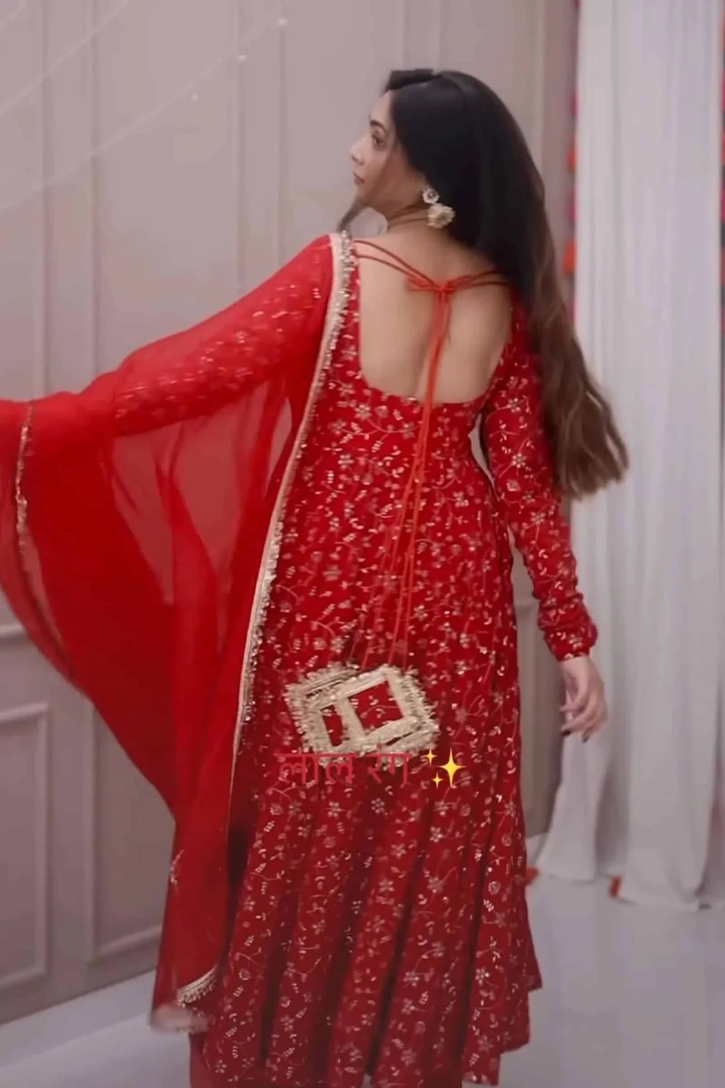 Woman wearing a red traditional outfit with a floral pattern and a red dupatta.