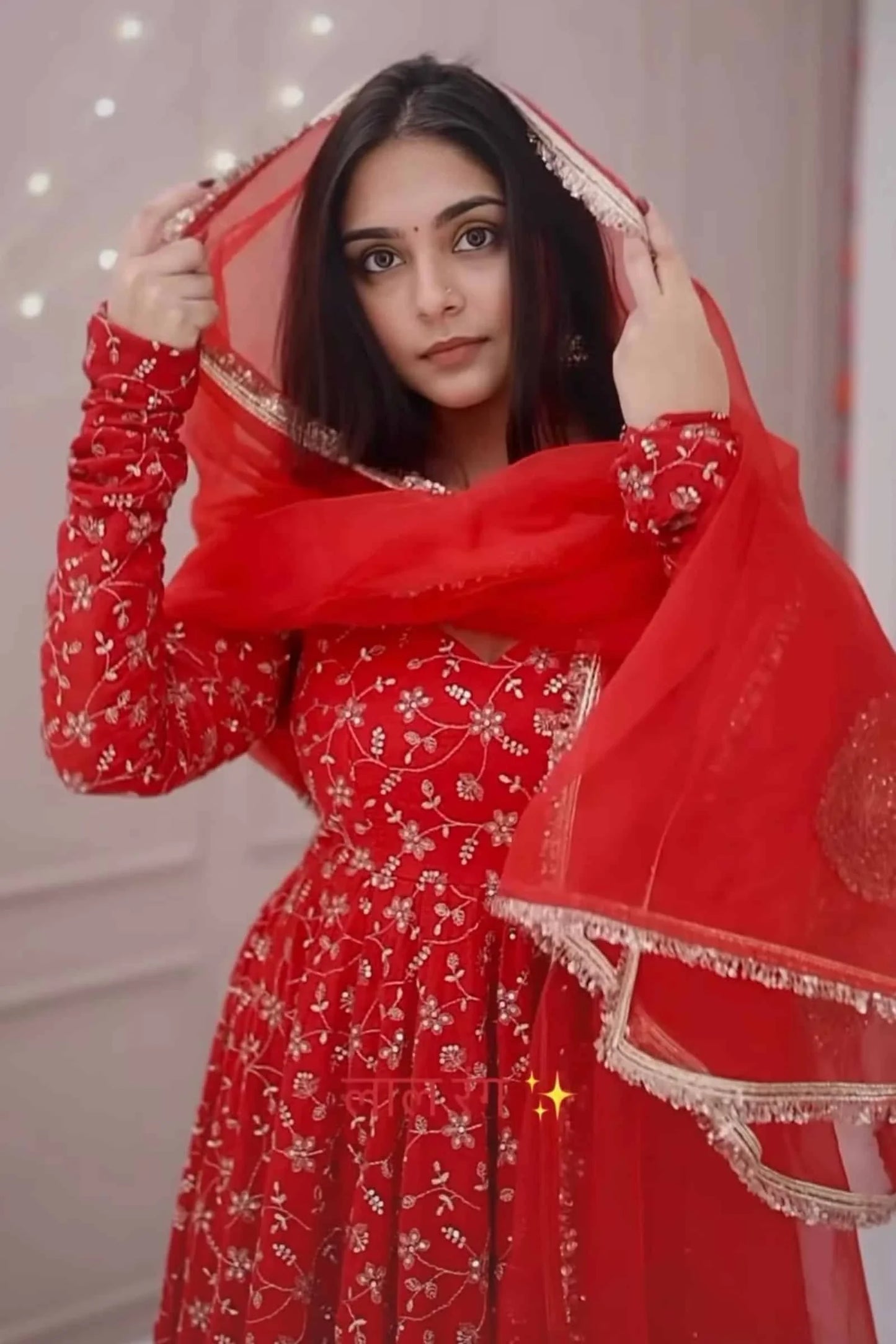 Woman wearing a red traditional outfit with a matching dupatta.