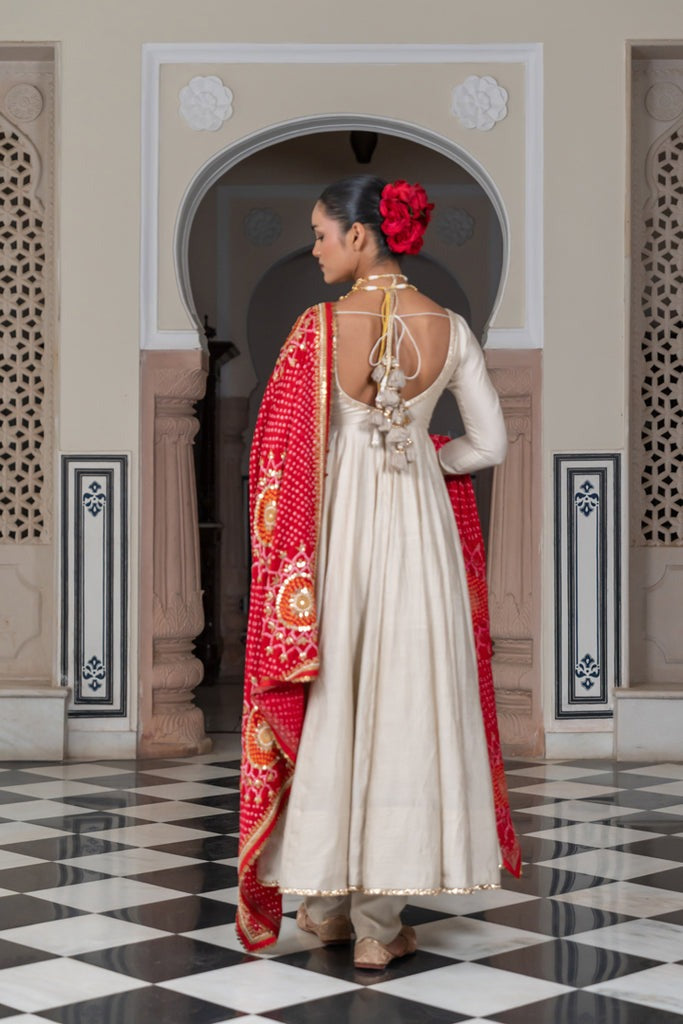 Woman in traditional attire with a red shawl in an ornate hall