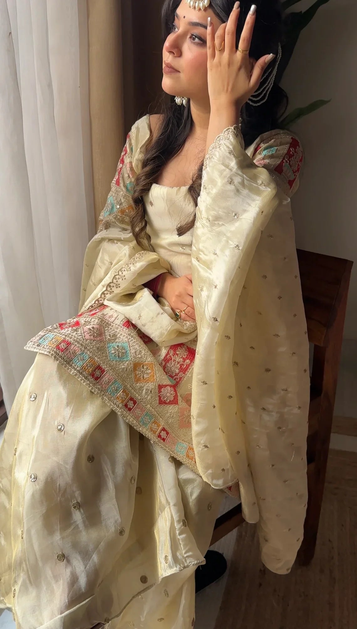 Woman in traditional attire with a colorful shawl, indoors.