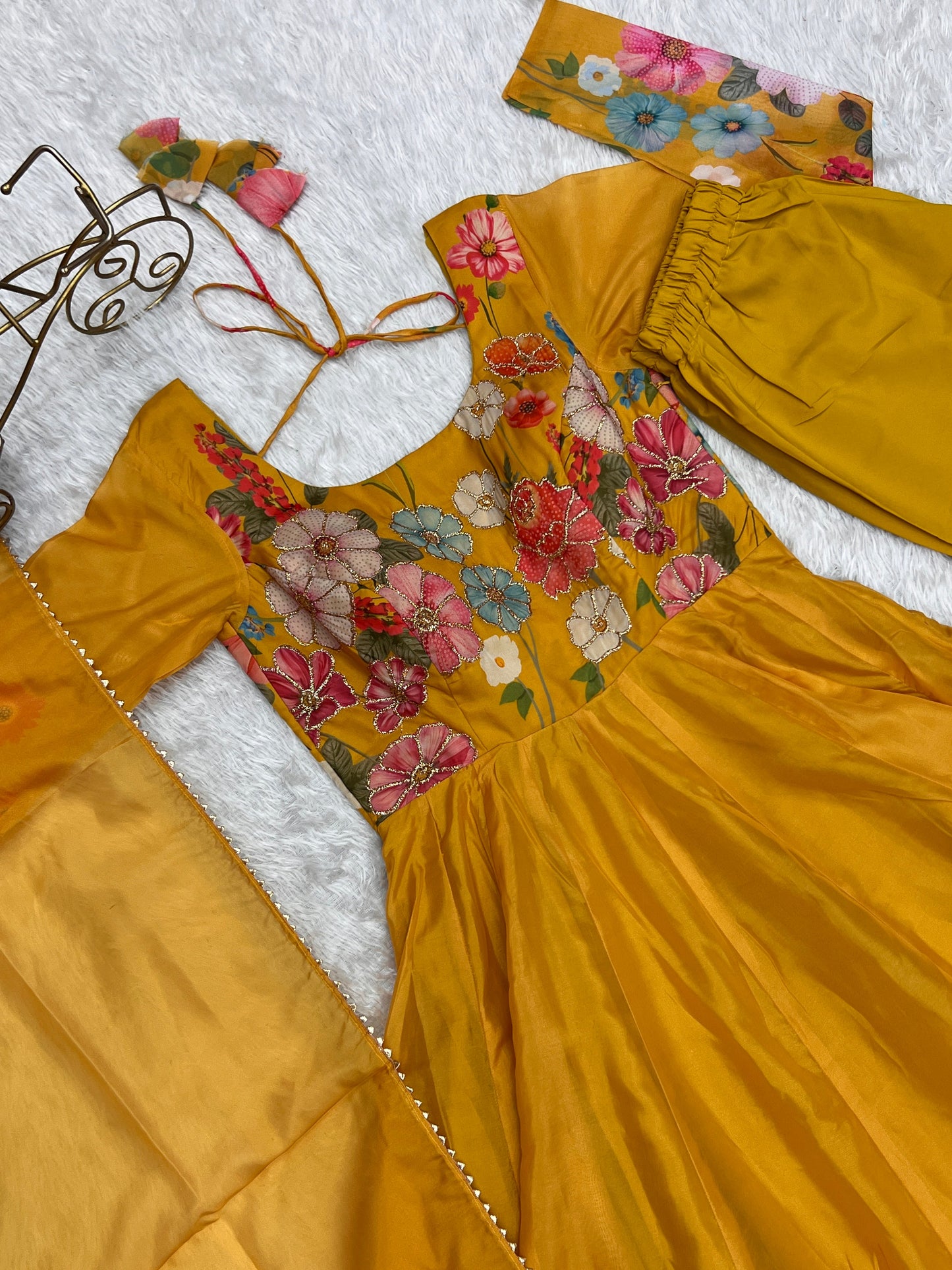 Yellow dress with floral embroidery on a textured surface