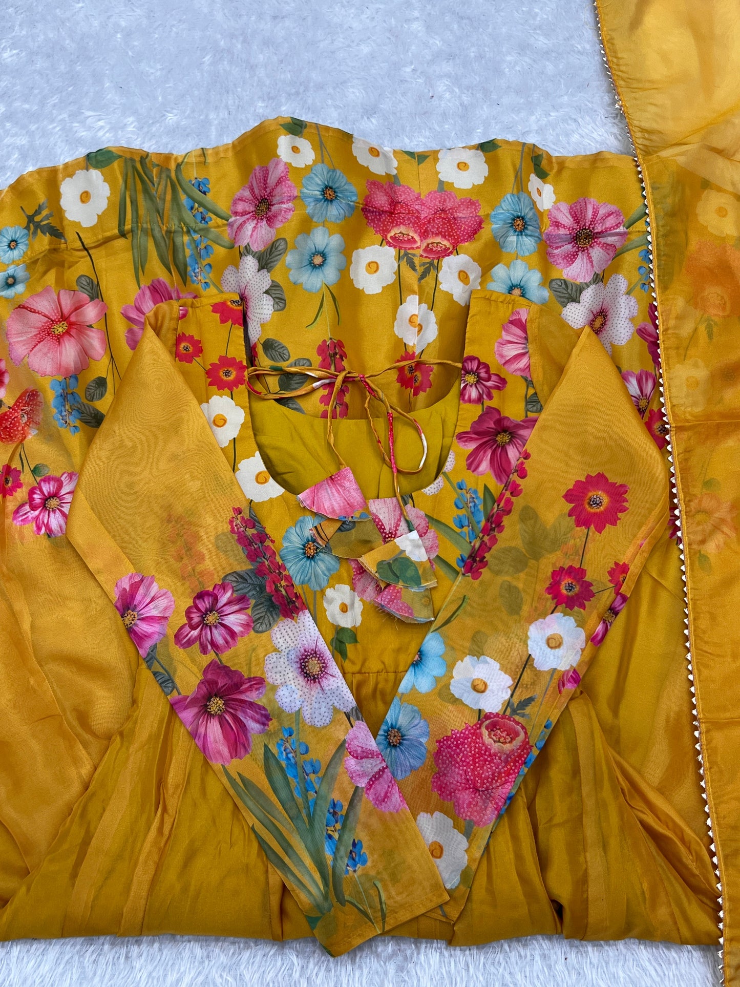 Yellow garment with floral patterns on a textured surface