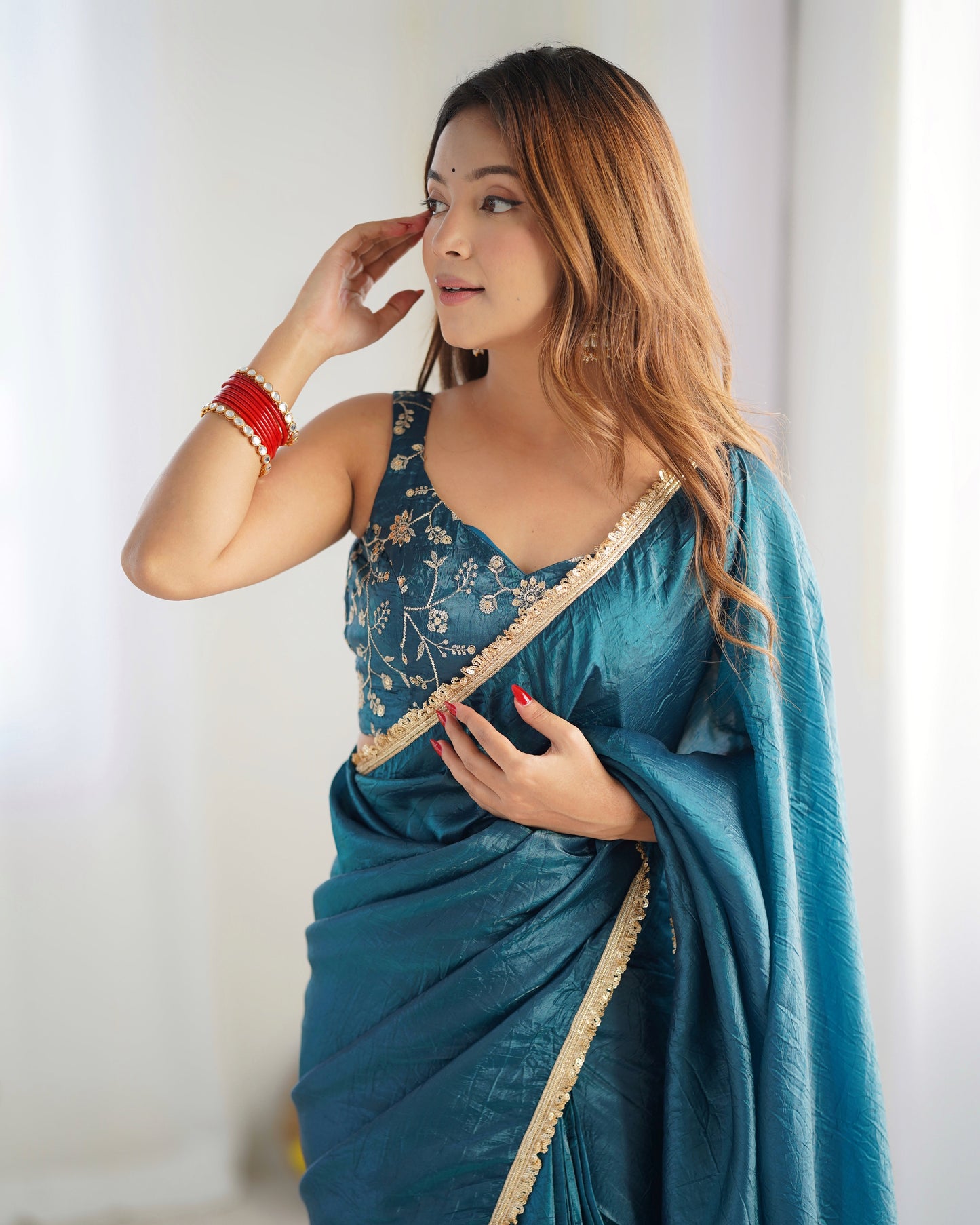 Woman wearing a blue saree with a white background