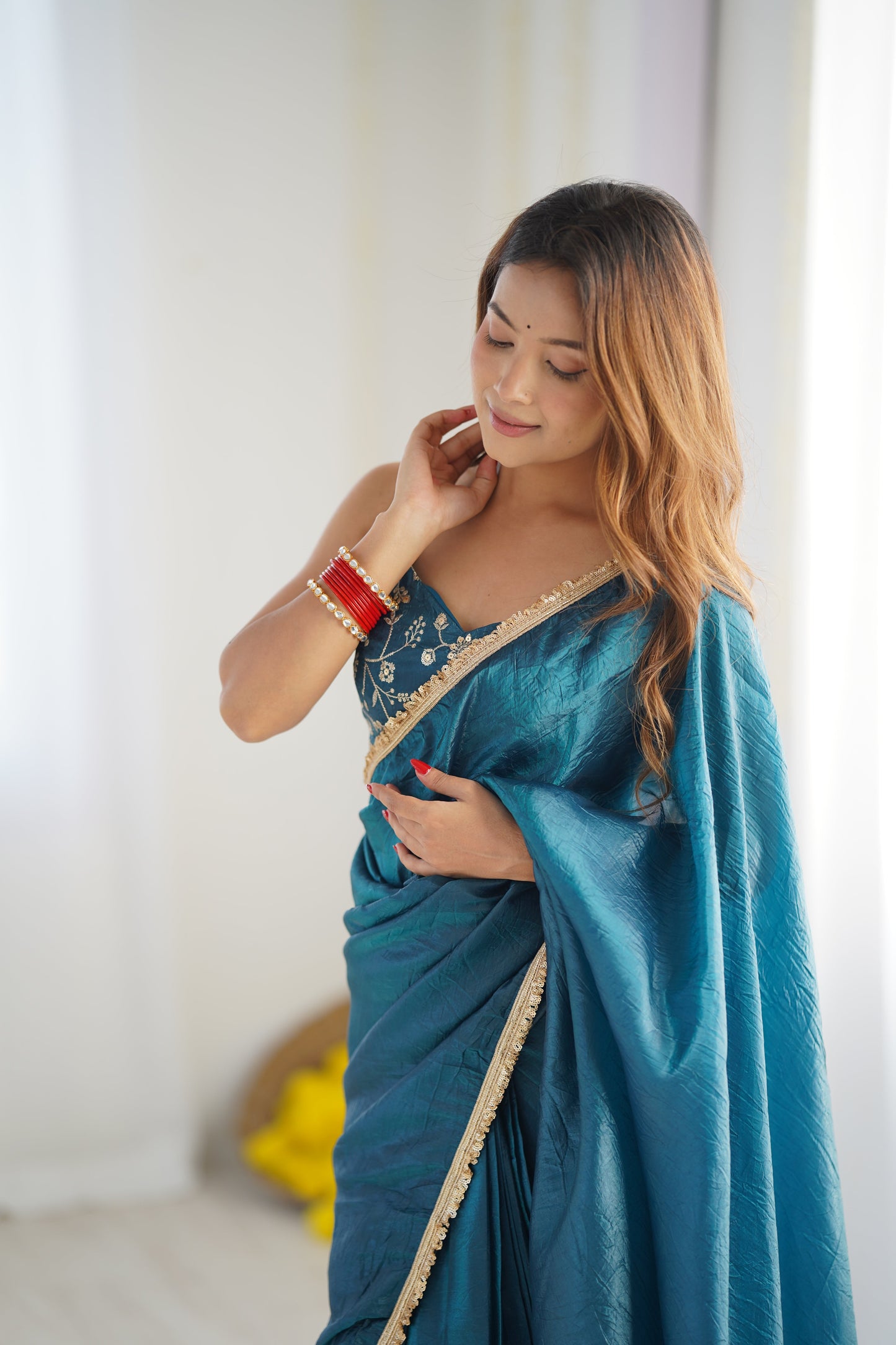 Woman wearing a blue saree with a white background