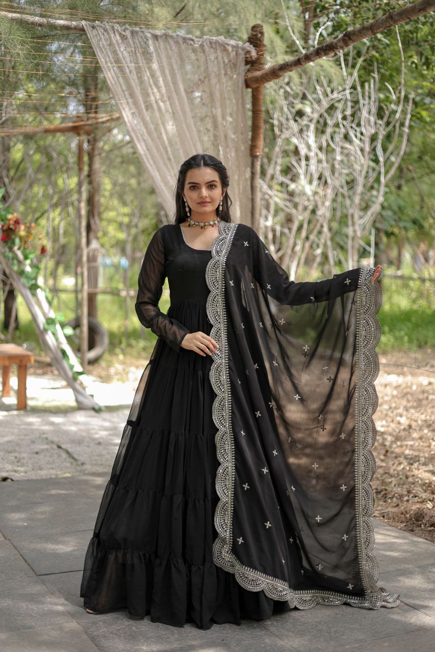 Woman in a black traditional outfit with a sheer dupatta in an outdoor setting
