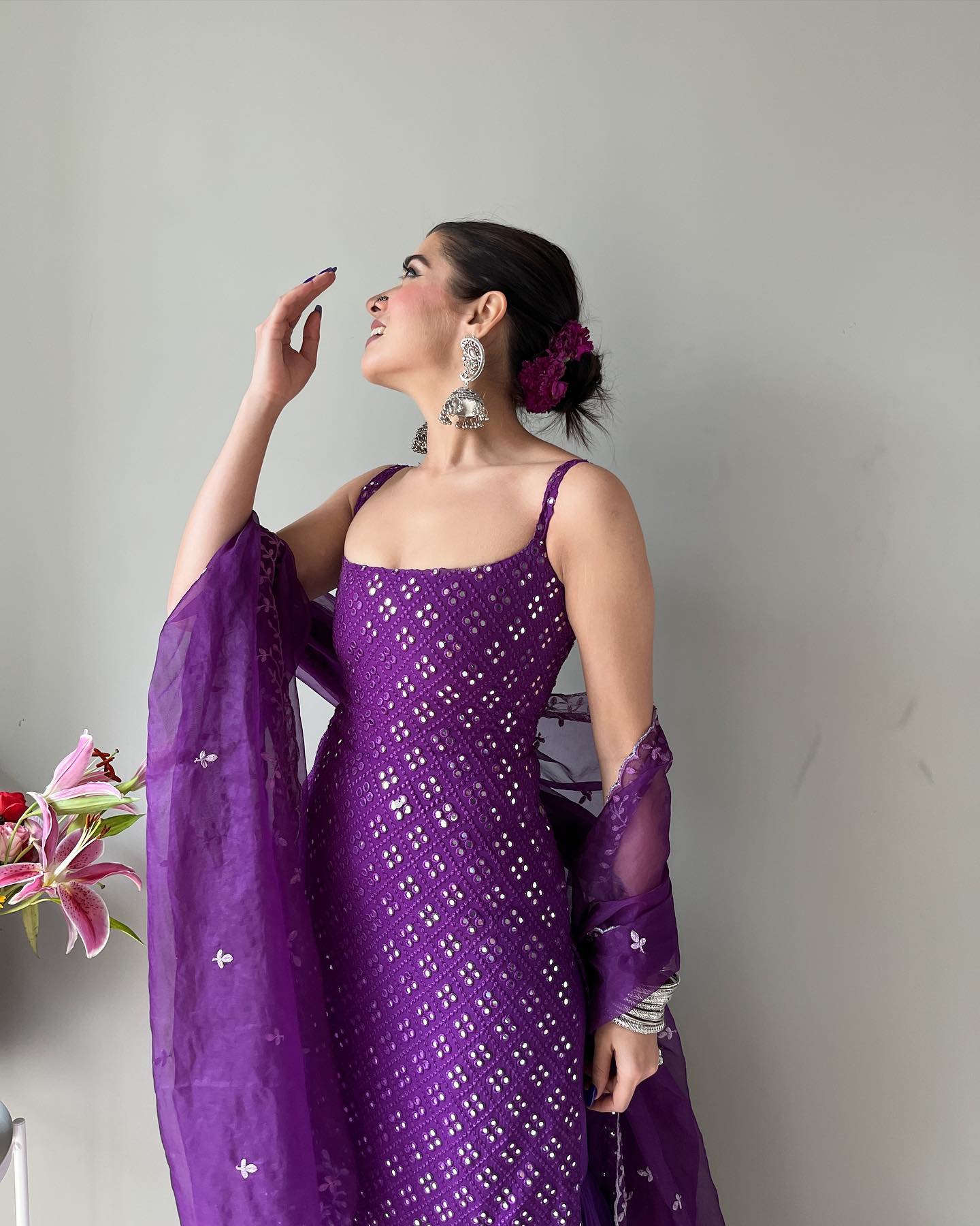 Woman in a purple saree with a floral background