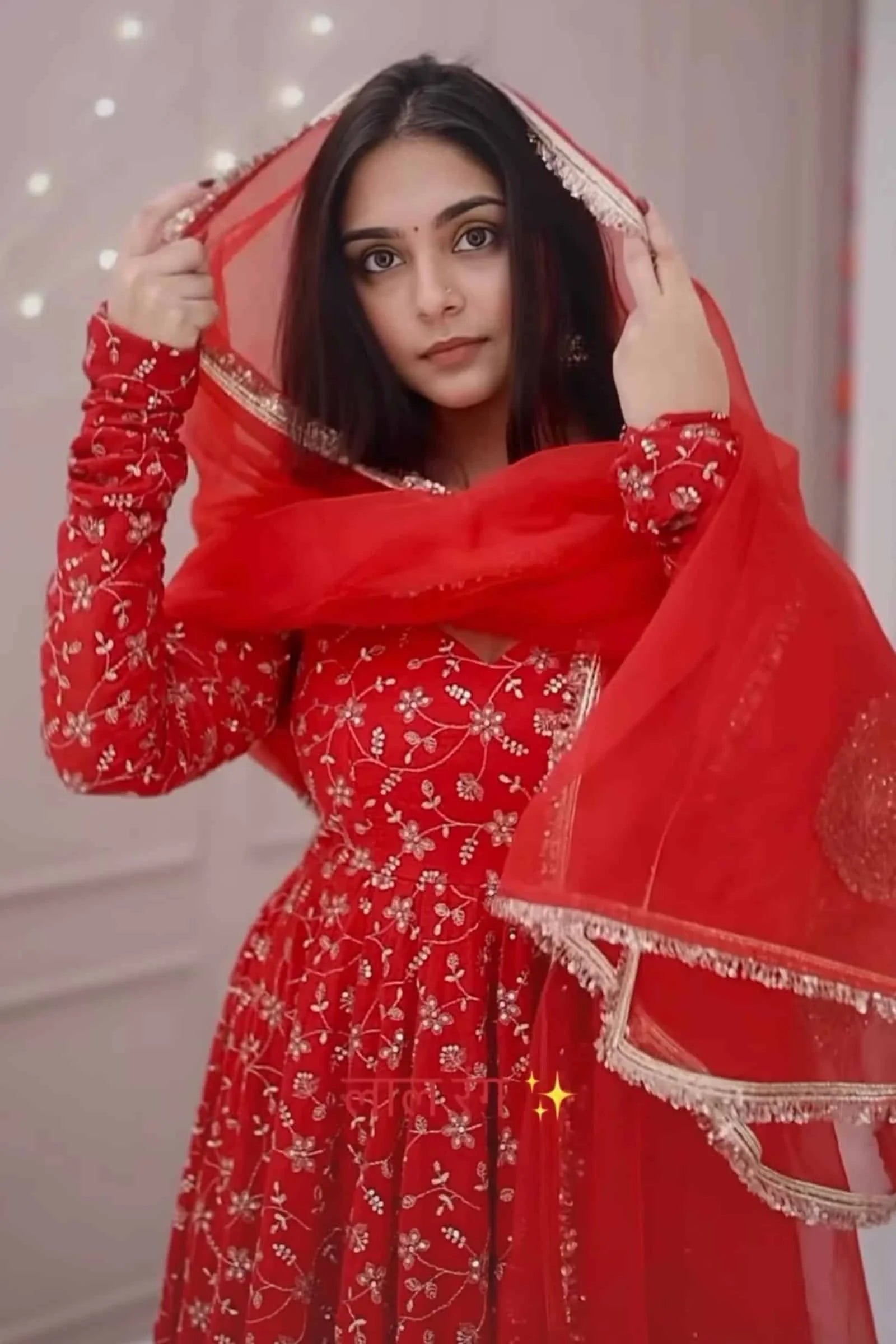Woman wearing a red traditional outfit with a matching dupatta.