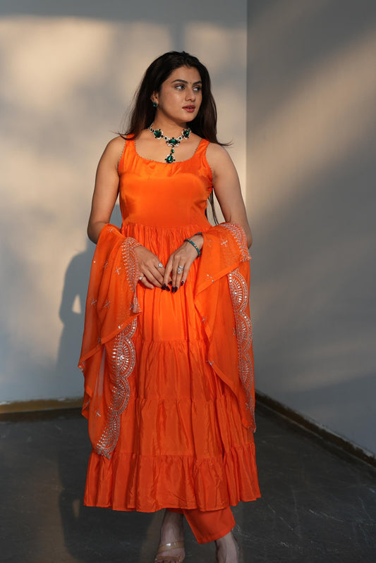 Woman wearing an orange dress with a plain background