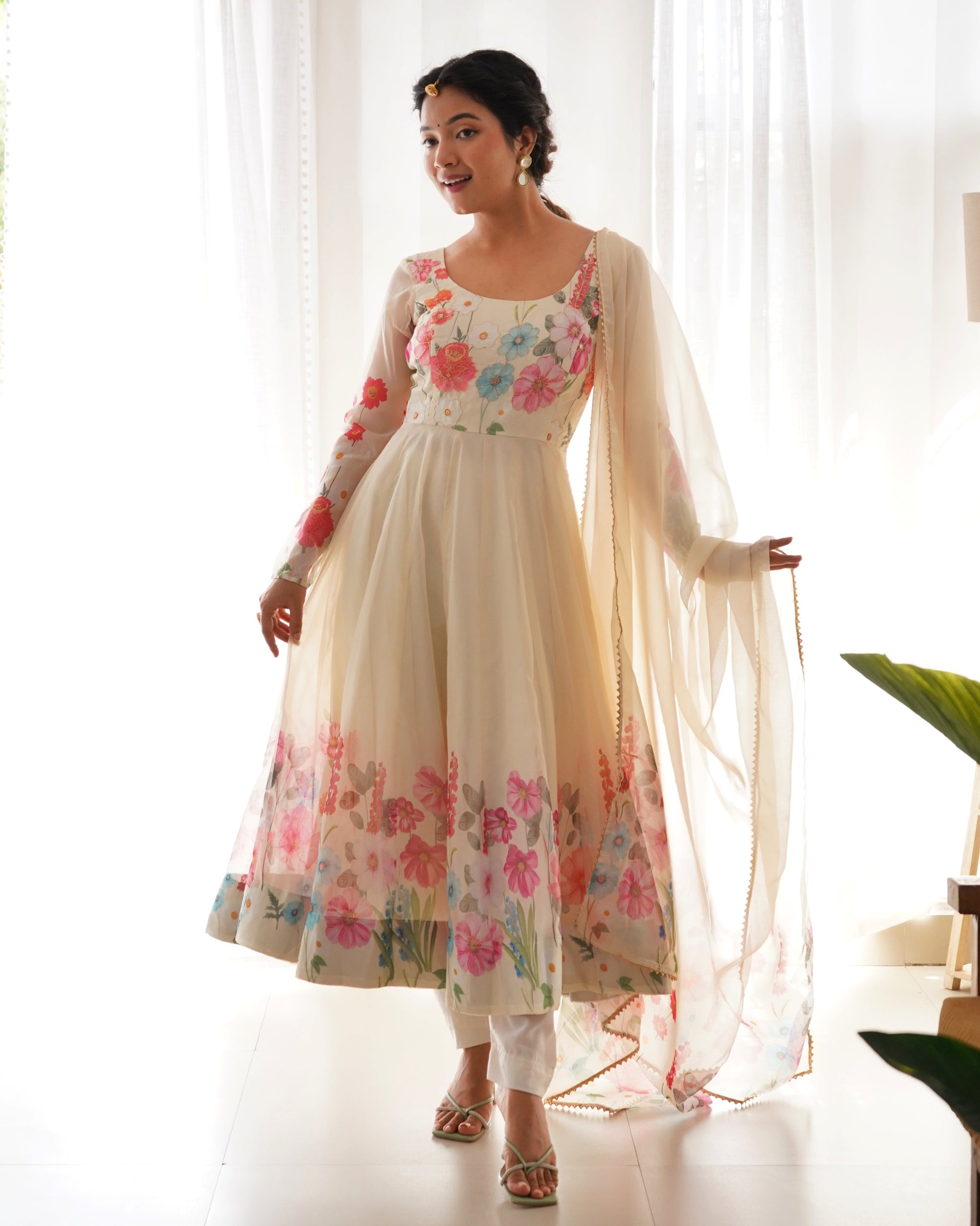Woman wearing a floral dress with a sheer dupatta in a bright setting