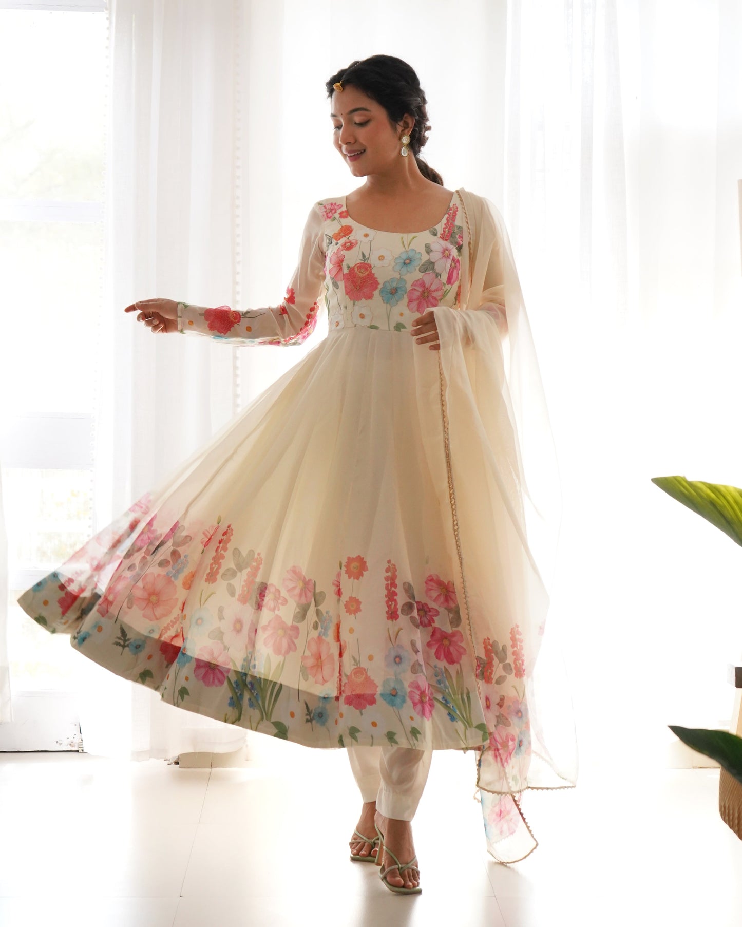 Woman wearing a floral dress with a sheer dupatta in a bright setting