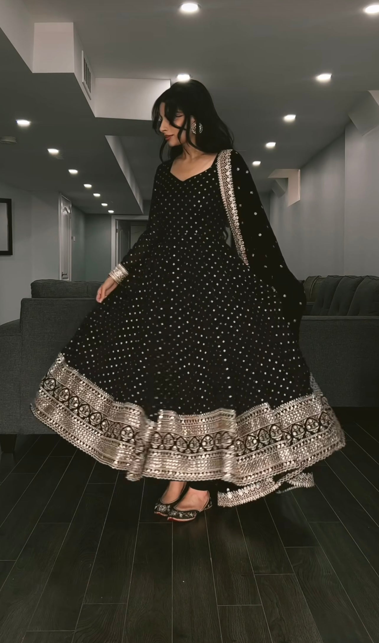 Woman wearing a black and white traditional outfit in a modern interior setting