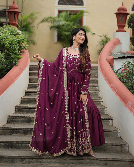 Woman in a purple embroidered dress standing on steps outdoors
