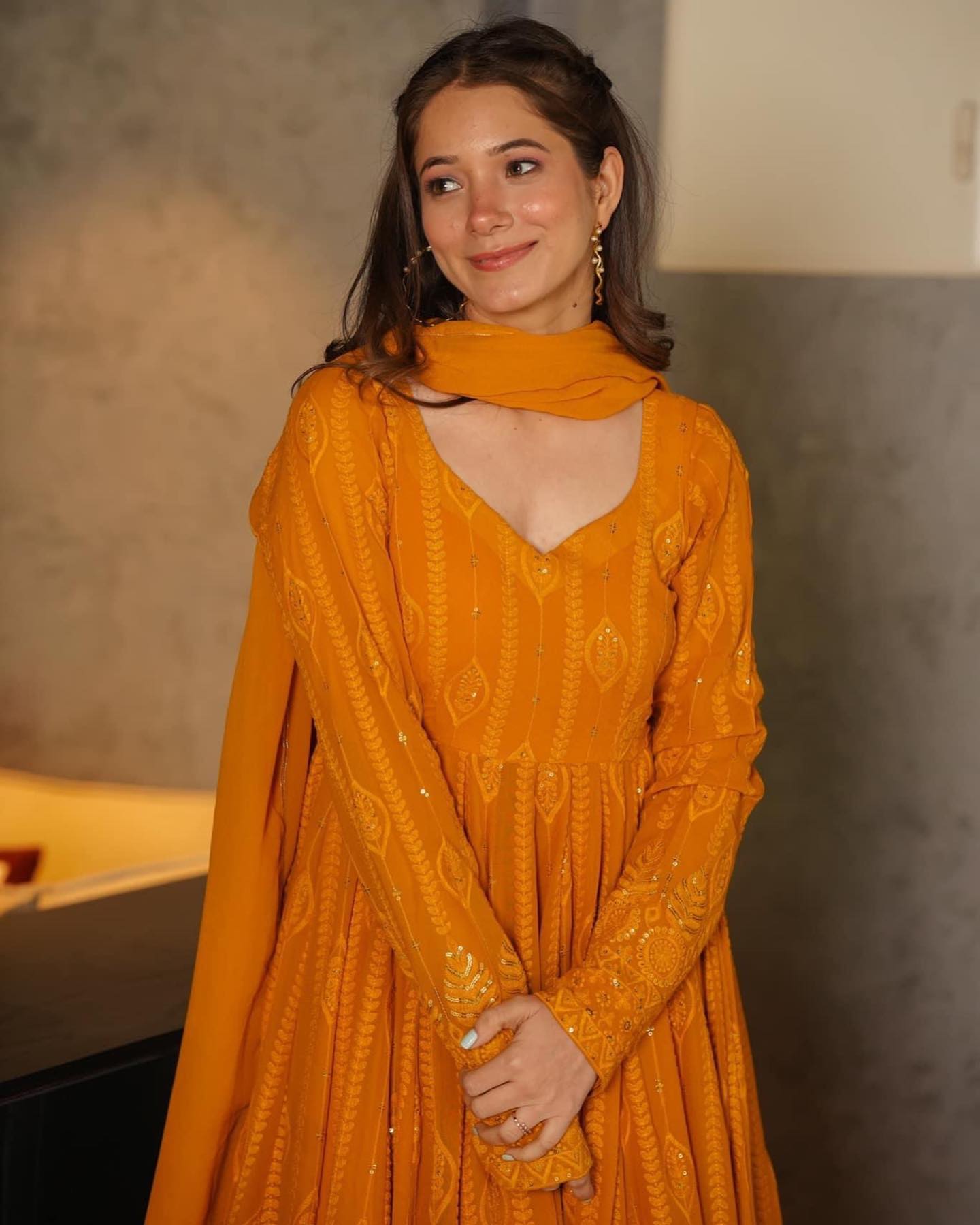 Woman wearing a mustard yellow dress with a blurred background